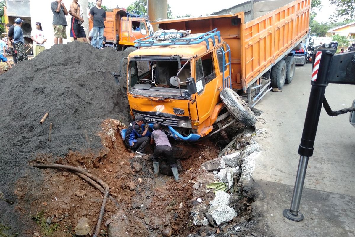 Truk pasir terperosok ke saluran air di perempatan Jalan Pinang Kali Jati, Jakarta Selatan, Kamis (21/3/2019) 