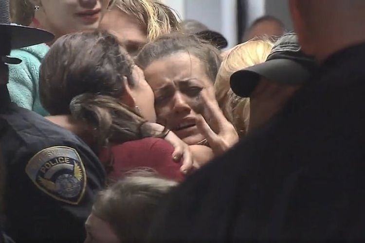 Kayla Williams menangis saat dipeluk oleh seorang kerabat usai dievakuasi dari sebuah tambang. Dia bersama dengan dua orang lainnya terjebak di bawah tanah sebuah tambang batu bara di West Virginia, Amerika Serikat. (ABC News via Daily Mail).