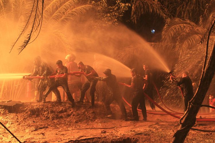 Sejumlah petugas berusaha memadamkan api di sumur minyak ilegal yang berada di kawasan pemukiman penduduk Desa Mata Ie, Kecamatan Ranto Peureulak, Aceh Timur, Sabtu (12/3/2022). Kebakaran di salah satu sumur minyak ilegal pada Jumat (11/3/2022) sekitar pukul 23.30 WIB tersebut mengakibatkan tiga warga mengalami luka bakar serius.