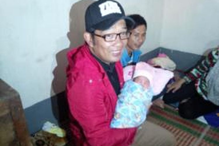 Wali Kota Bandung Ridwan Kamil menggendong bayi perempuan yang dilahirkan di tengah bencana