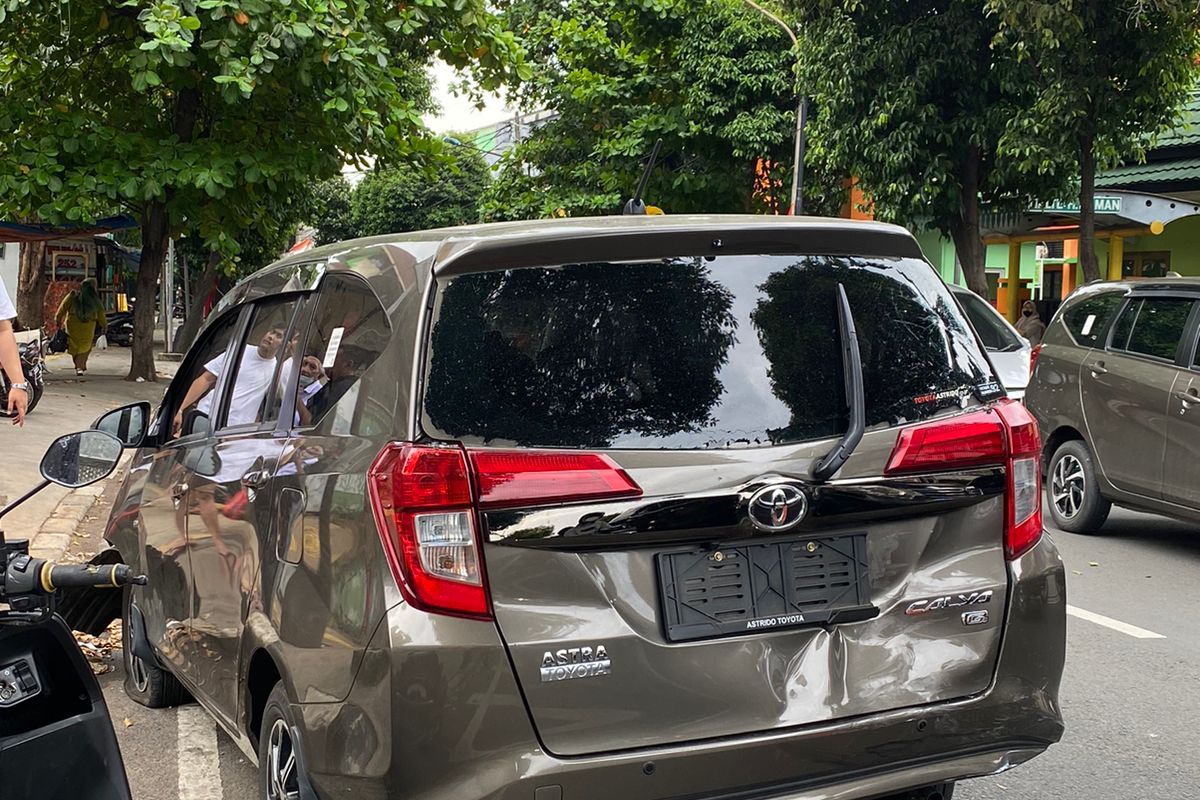 Bagian belakang mobil ringsek akibat ditabrak oleh pengendara motor di Jalan Haji Naman, Kelurahan Pondok Kopi, Kecamatan Duren Sawit, Jakarta Timur, Senin (27/3/2023).
