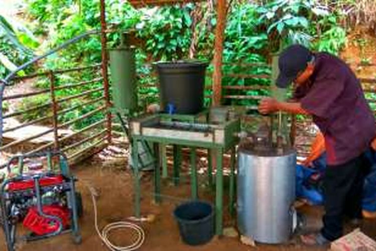 Sudaryanto saat mengisi arang ke dalam tabung gasifier yang berfungsi sebagai sumber energi untuk menghidupkan mesin genset di Dusun Satak, Desa Bumbung, Kecamatan Sadaniang, Kabupaten Mempawah, Kalimantan Barat (27/10/2016)