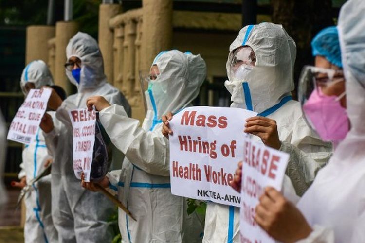 Petugas kesehatan dengan pakaian pelindung berdemonstrasi, menyerukan pemerintah untuk melepaskan tunjangan mereka di tengah meningkatnya infeksi covid-19, di depan sebuah rumah sakit di Manila pada 30 Agustus 2021. 