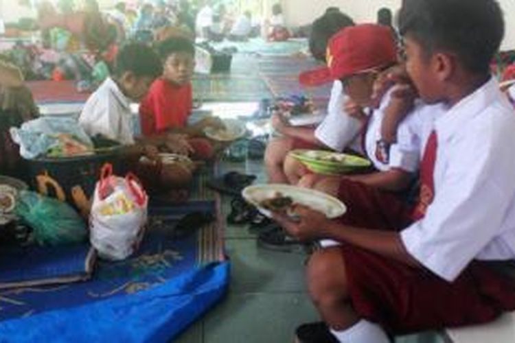 Sejumlah anak sedang makan siang di pengungsian Desa Batu Karang sebelum berangkat ke sekolah untuk mengikuti ujian kenaikan kelas, Senin (8/6). Mereka adalah pengungsi dari Desa Guru Kinayan yang terletak di zona bahaya lereng Gunung Sinabung, di Kabupaten Karo, Sumatera Utara. Hingga saat ini tercatat ada 2.489 pengungsi dari empat desa.