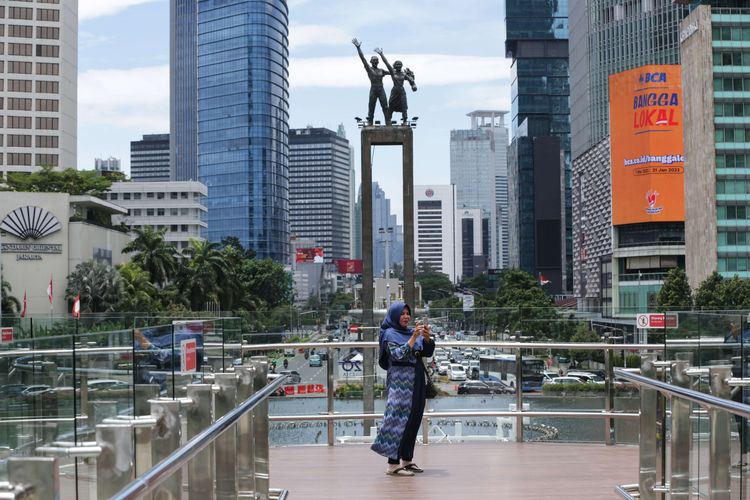 Pengunjung berfoto di anjungan Halte Transjakarta Bundaran Hotel Indonesia, Jakarta, Jumat (28/10/2022). Warga Ibu Kota datang ke halte yang belum sepenuhnya rampung itu untuk antre berfoto demi dapat latar belakang Patung Selamat Datang.