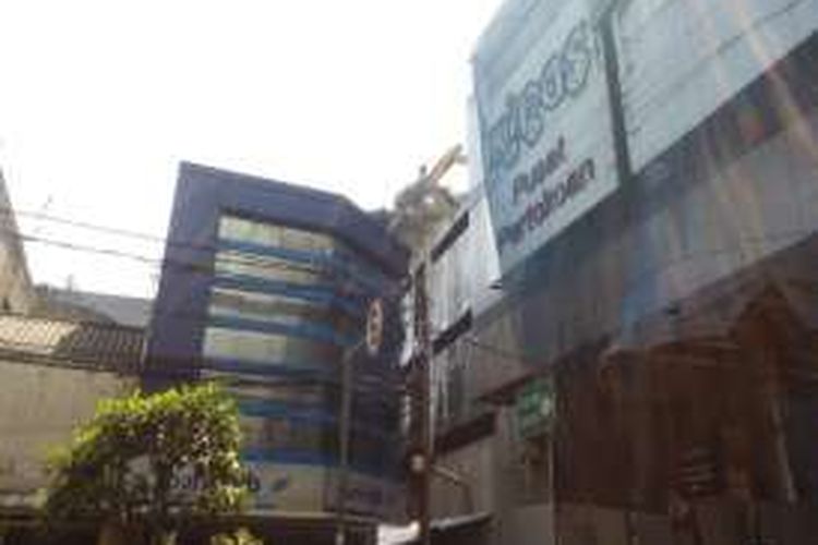 Sebuah eskavator saat tengah melakukan pembongkaran gedung eks pusat perbelanjaan Kings di lantai empat gedung. Lantaran terjadi kesalahan teknis, puing reruntuhan bangunan menimpa pertokoan dan kendaraan warga di Jalan Kepatihan, Bandung, Rabu (6/4/2016)
