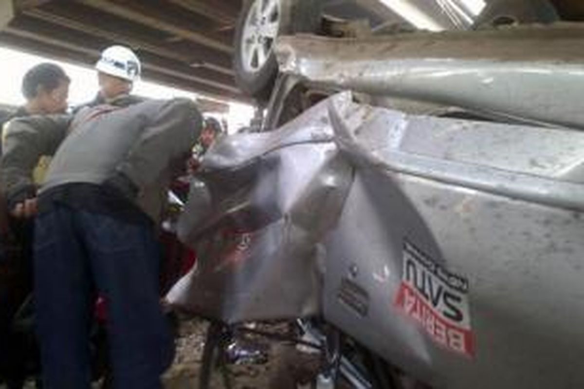 Mobil Toyota Avanza terbalik setelah tertabrak kereta api di bawah flyover Tanjung Barat, Jagakarsa, Jakarta Selatan, Rabu (14/8/2013) sekiar pukul 16.00. 