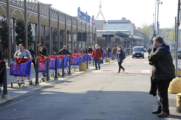Antrean pengunjung yang hendak memasuki sebuah supermarket di Milan, Italia, saat lockdown diterapkan. Gambar diambil pada 21 Maret 2020.
