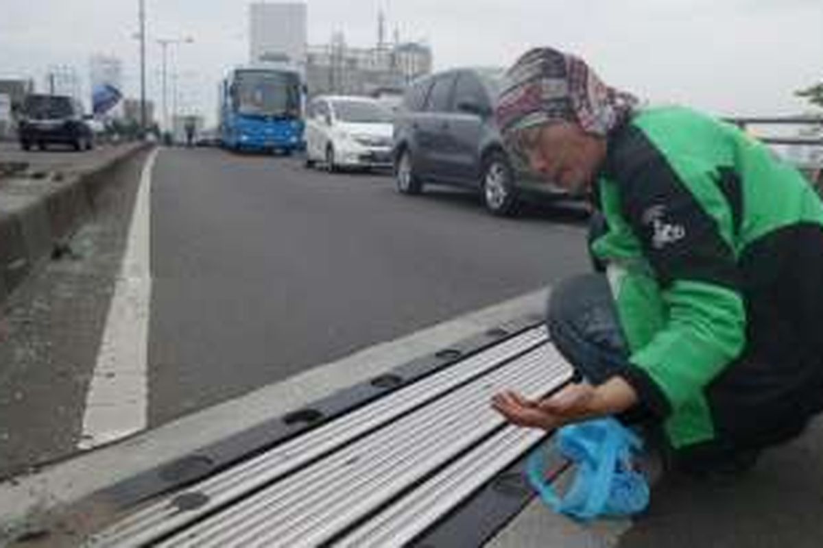 Driver Go-Jek melakukan aksi sosial #GerakanBersihRanjauPaku di Flyover, Jalan K.H Hasyim Ashari, Jakarta, Minggu (10/7/2016).