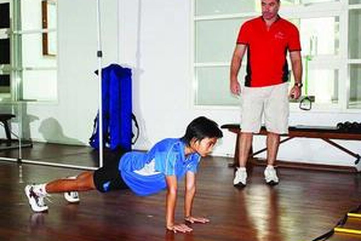 Rhidatia Eka Putri, peserta audisi beasiswa bulu tangkis Djarum, menjalani tes fisik awal bersama pelatih fisik Jason Kurfurst (kanan), Sabtu (4/7). 