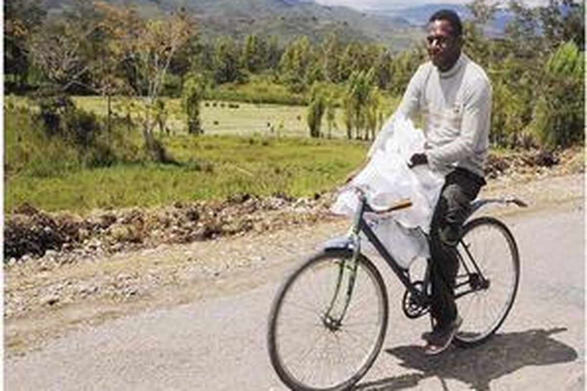 Fredy Lokobal (21), warga Desa Sinata, Distrik Asolokobal, Kabupaten Jayawijaya, Papua, bersepeda membawa tiga karung surat suara pemilu presiden dari ibu kota distrik ke kampungnya yang berjarak sekitar 4 kilometer, Selasa (7/7). Pemungutan suara di sejumlah kabupaten di Papua tidak bisa dilaksanakan serentak pada 8 Juli karena cuaca buruk dan kabut menghalangi pengiriman surat suara. 