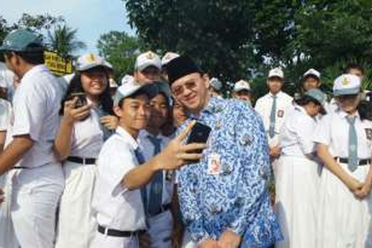 Gubernur DKI Jakarta Basuki Tjahaja Purnama berfoto bersama siswa SMA usai upacara Peringatan Hari Otonomi Daerah Tahun 2016. 