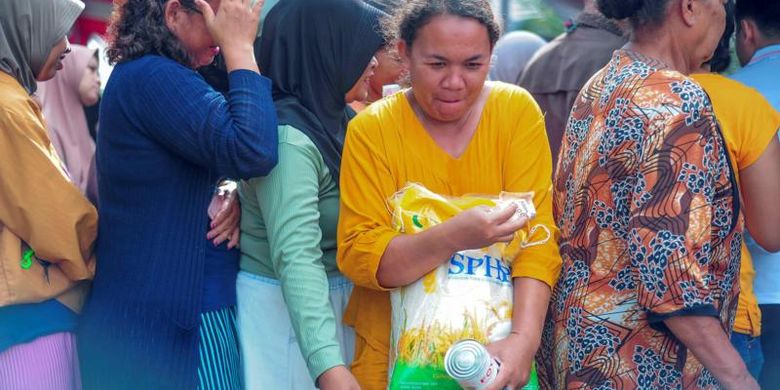 Seorang warga berusaha keluar dari antrean usai membeli beras dan susu saat Gerakan Pangan Murah di Pinang Merah, Alam Barajo, Jambi, Rabu (06/03).