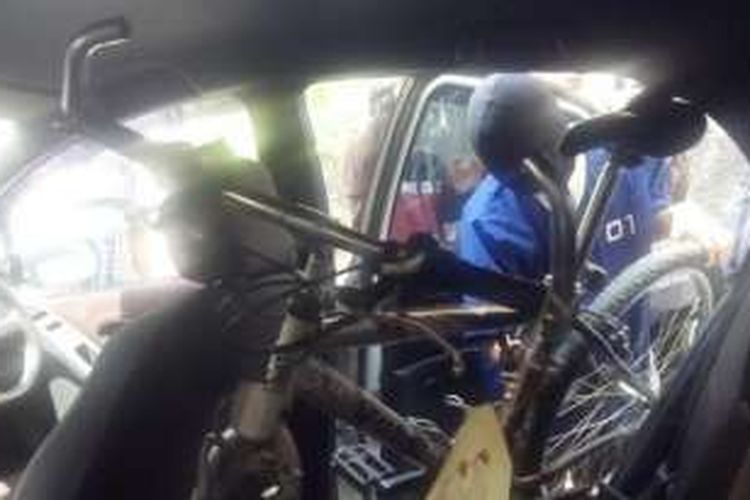 Tersangka memeragakan cara memasukkan sepeda ke dalam mobil yang ia curi dari tantenya di Solo, Jawa Tengah.