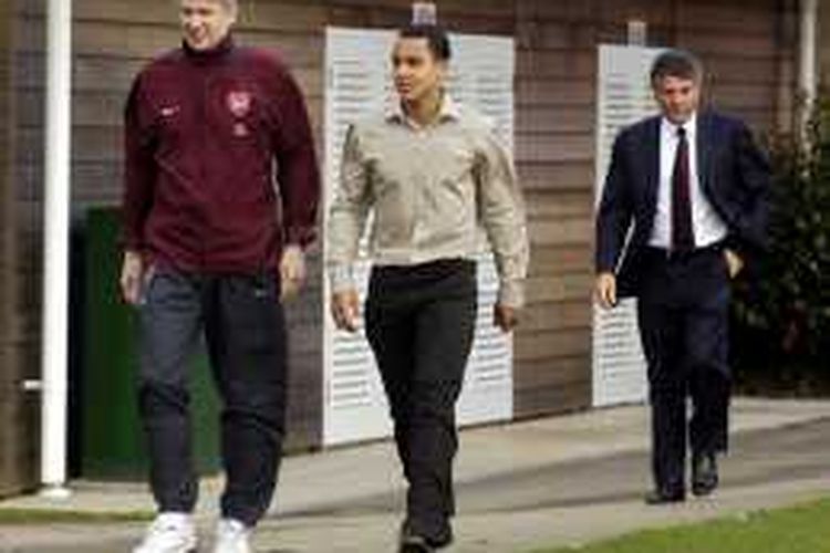 Manajer Arsenal, Arsene Wenger (kiri), berjalan bersama Theo Walcott (tengah) yang masih berusia 16 tahun di lapangan latihan di Hetfordshire, 20 Januari 2016. 