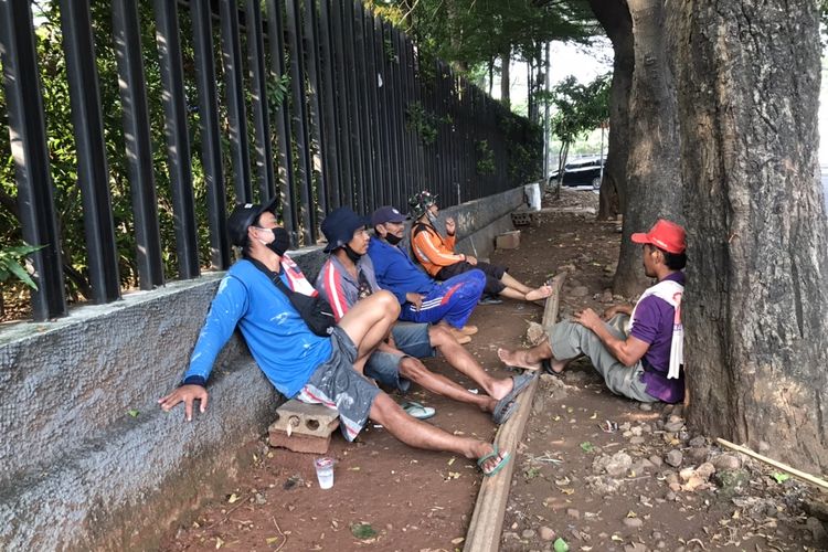 Para tukang gali harian sedang duduk menunggu pengguna jasa mereka di pinggir Jalan Adhyaksa Raya, Lebak Bulus, Cilandak, Jakarta pada Rabu (28/10/2020) siang. Para tukang gali harian ini mayoritas berasal dari Brebes, Jawa Tengah dan sudah mengadu nasib di Jakarta selama puluhan tahun.