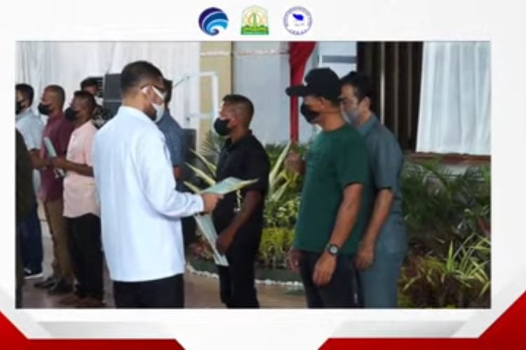 Anggota DPR-RI asal Aceh, Nasir Djamil, menyerahkan sertifikat lahan, kepada Perwakilan mantan Gerakan Aceh Merdeka, pada kegaitan peringatan Hari Damai Aceh ke-16, yang berlangsung secara tatap muka dan virtual di Gedung Serba Guna, Stadion Lhong Raya, Banda Aceh, Minggu, 15 Agustus 2021. 