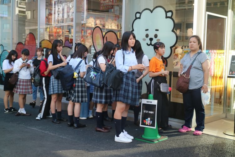 Sejumlah pelajar berbaris rapi untuk menunggu giliran masuk ke dalam Line Friend Store di Harajuku, Jepang, Jumat (29/6/2018). Para pelajar ini merupakan pemenang lucky draw yang berhak mendapat potongan harga 20 persen untuk setiap pembelian pernak-pernik karakter BT21 dari boyband BTS.