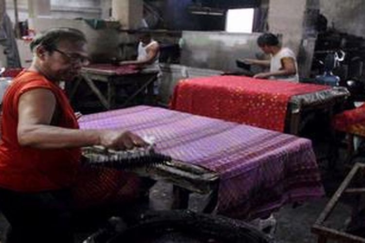 Para perajin menyelesaikan pembuatan batik cap di salah satu workshop toko batik di kawasan Kampung Batik Laweyan, Kota Solo, Rabu (9/4/2013). Sebagai sentra batik tertua di Solo dan kawasan heritage, Laweyan menjadi salah satu tujuan wisatawan bila mengunjungi kota ini.
