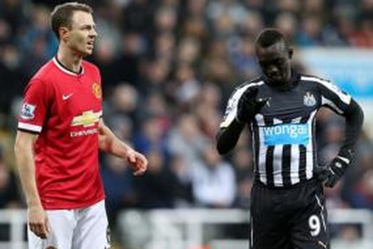 Bek Manchester United, Jonny Evans (kiri), dan penyerang Newcastle United, Papiss Cisse (kanan).