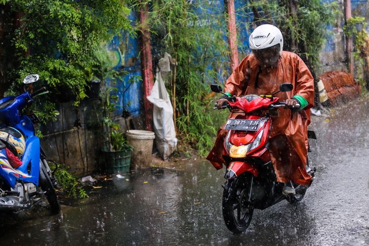 Pengendara sepeda motor melintas dibawah guyuran hujan lebat di jalan Karet Sawah, Jakarta Selatan, Senin (9/10/2017). Curah hujan yang tinggi menyebabkan sejumlah ruas jalan di Ibu Kota tergenang.