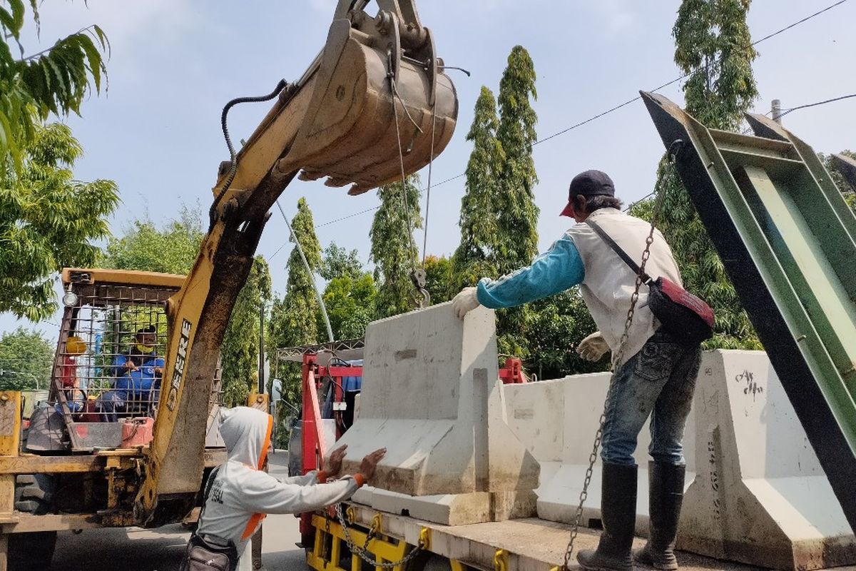 Petugas DPUPR Kota Tegal dengan bantuan alat berat mengangkut beton  pembatas jalan untuk menutup akses masuk ke perkampungan di jalan nasional dan provinsi, Rabu (22/4/2020)
