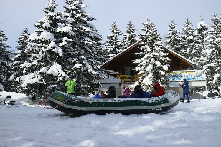 Wisatawan mencoba atraksi wisata snow rafting di Rusutsu Ski Resort, Kota Rusutsu, Prefektur Hokkaido, Jepang, Rabu (13/2/2019). Rusutsu memiliki banyak aktivitas unik yang ditawarkan, terutama ketika musim dingin seperti snowboarding, snow raftin maupun ski.
