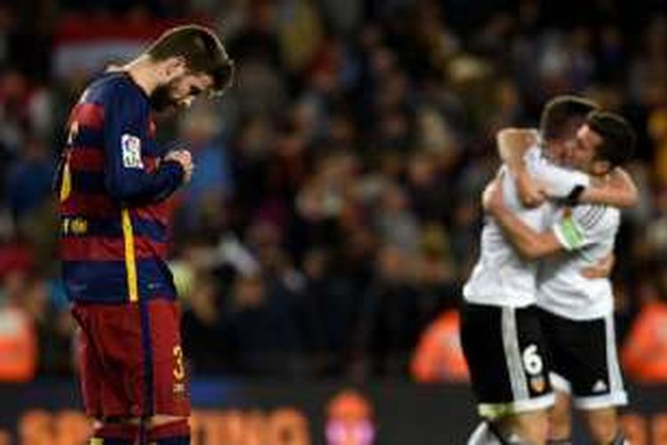 Gerard Pique tertunduk lesu seusai gawang Barcelona dijebol Valencia pada pertandingan La Liga di Camp Nou, Minggu (17/4/2016).