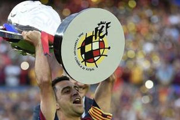 Xavi Hernandez dengan trofi juara La Liga kedelapan miliknya, Sabtu (23/5/2015). 