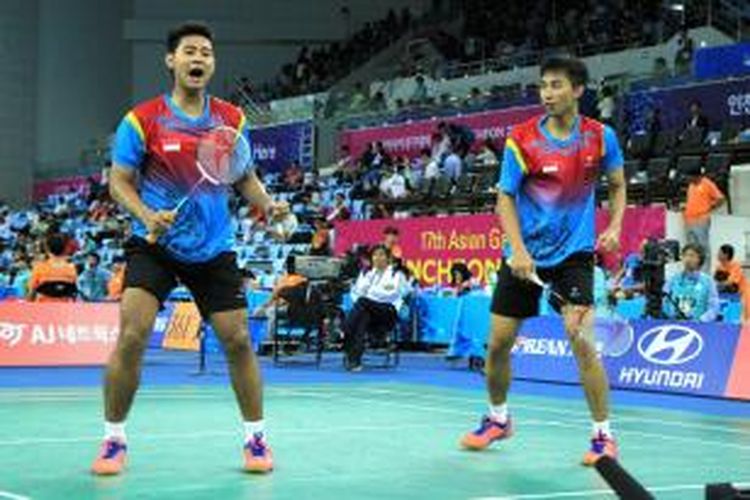 Pebulu tangkis ganda putra Indonesia, Angga Pratama (kiri)/Rian Agung Saputro, bereaksi setelah meraih poin saat menghadapi ganda Tiongkok, Cai Yun/Fu Haifeng, pada babak 16 besar nomor perorangan Asian Games 2014 di Incheon, Korea Selatan, Kamis (25/9/2014).