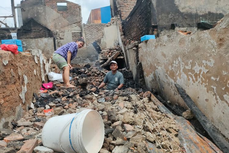 Korban kebakaran di Koja, sepasang suami istri mengais puing-puing bangunan rumah mereka mencari perhiasan yang tertinggal, pada Rabu (17/11/2021).