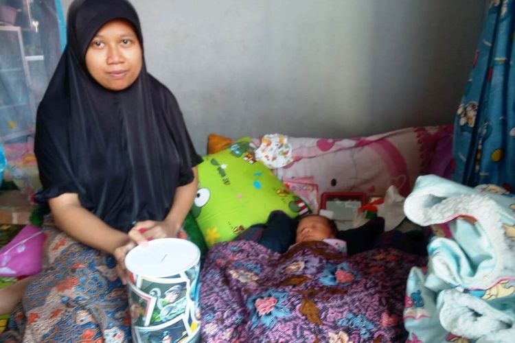 Riska (27) bersama bayinya, yang baru berumur sepekan di rumahnya di Desa Rahong, Cianjur, Jawa Barat, Jumat (17/01/2020). Riska membayar biaya persalinan anak pertamanya itu menggunakan uang koin pecahan Rp1.000.