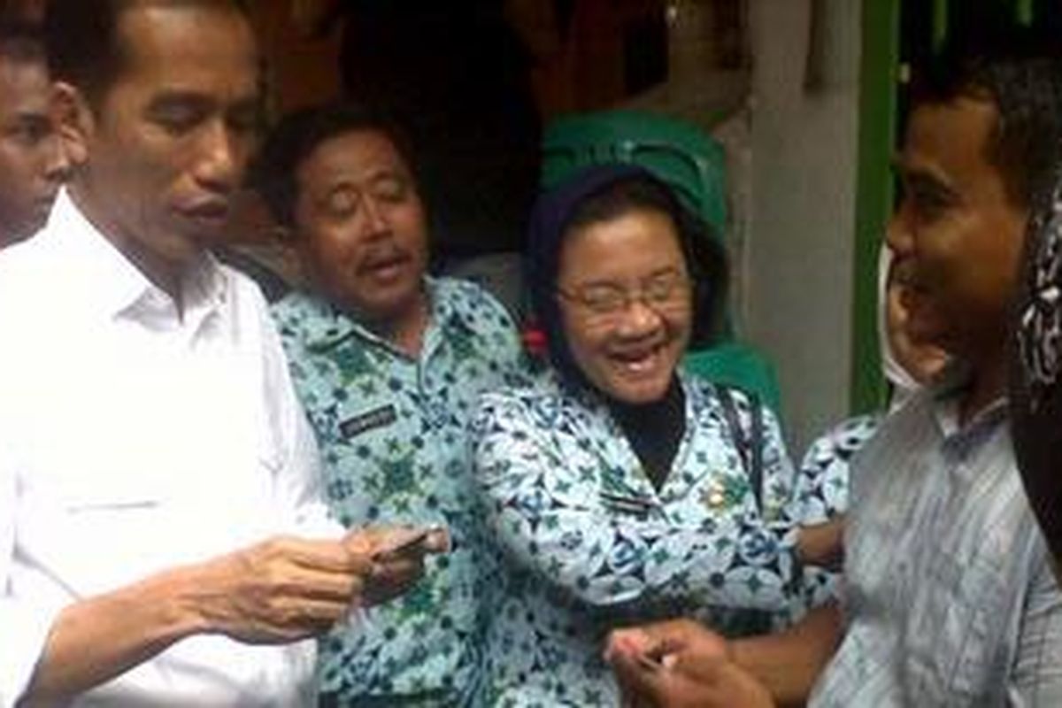 Gubernur DKI Jakarta Joko Widodo membagikan kartu sehat kepada warga di RW 06 Kelurahan Marunda, Kecamatan Cilincing, Jakarta Utara. Senin (12/11/2012). 
