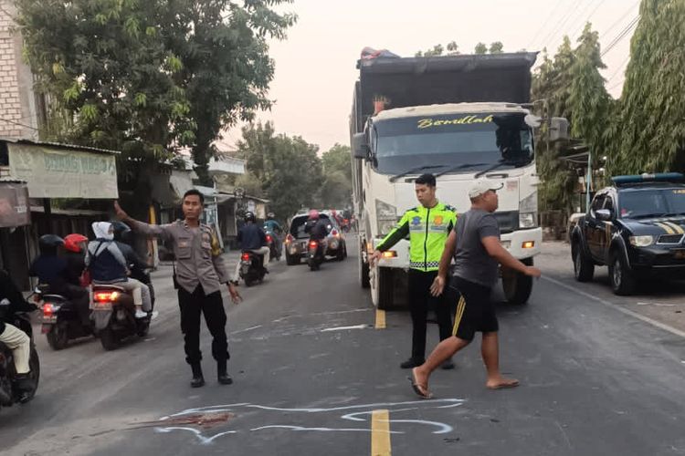 Polisi menunjukkan lokasi kecelakaan lalu lintas yang terjadi di Jalan Raya Desa Sembayat, Kecamatan Manyar, Gresik, Jawa Timur.