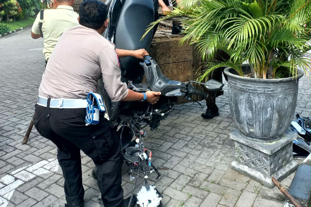 Seorang petugas kepolisian menaikkan sepeda motor yang dikendarai korban kecelakaan ke bak truk di Desa Dandong, Kecamatan Srengat, Kabupaten Blitar, Jumat (30/5/2025)