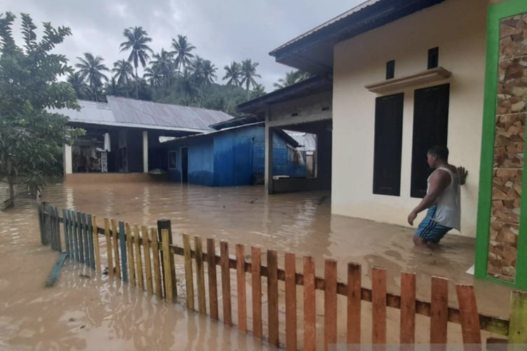Seorang warga berada di depan rumah yang direndam banjir di Kecamatan Bone di Kabupaten Bone Bolango, Gorontalo, Senin (22/8/2022).