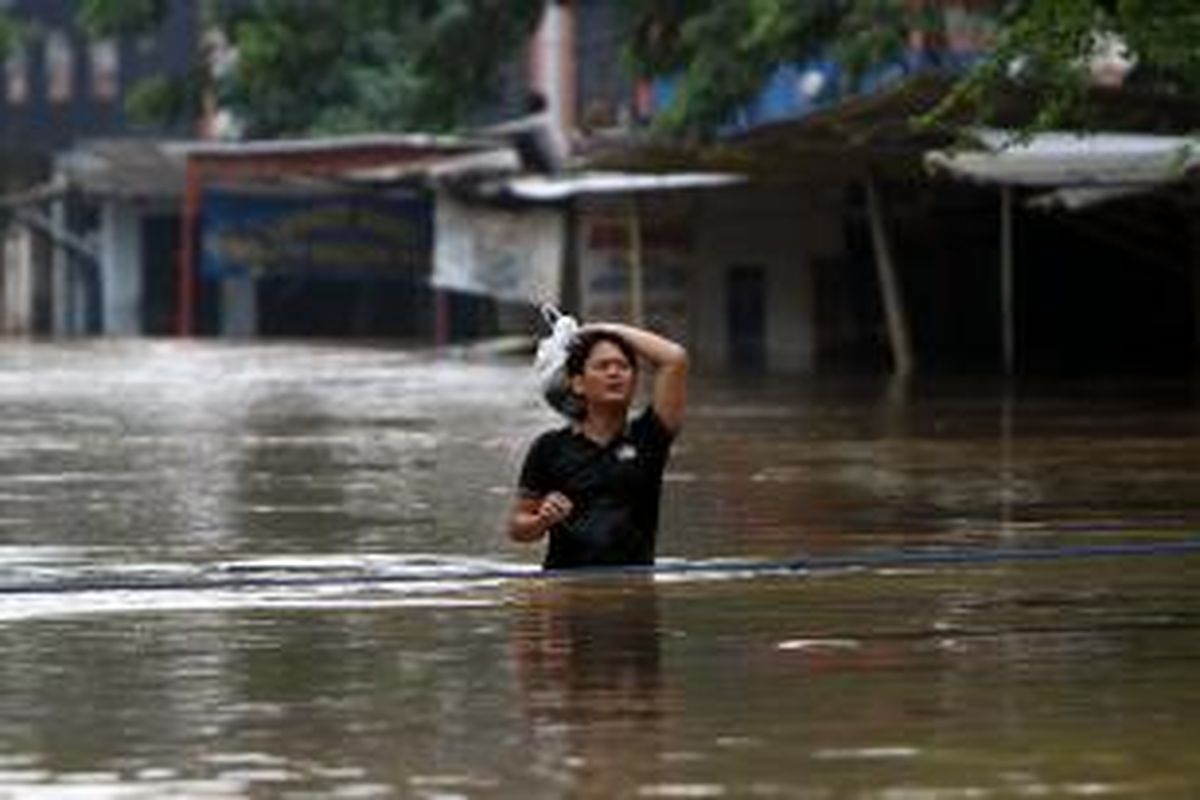 Warga melintasi banjir setinggi satu meter di Bukit Duri, Jakarta Selatan, Senin (13/1/2014). Sejumlah wilayah di Jakarta terendam banjir akibat curah hujan yang tinggi dan air kiriman dari Bogor. TRIBUNNEWS/HERUDIN