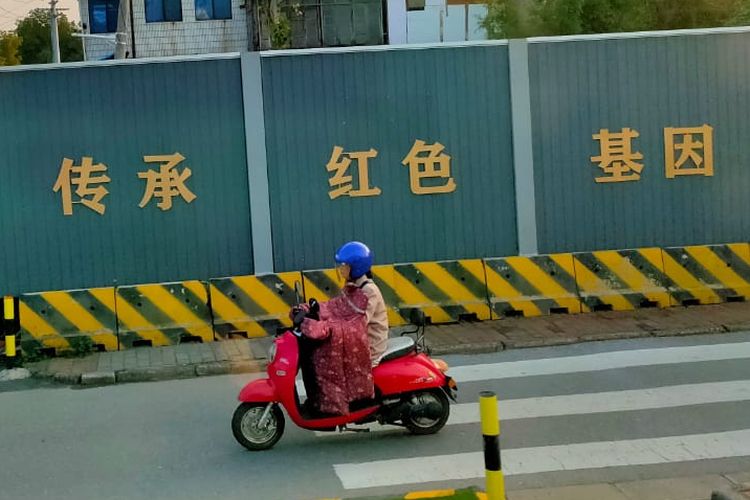 Pengendara sepeda motor pakai selimut di China saat musim dingin.