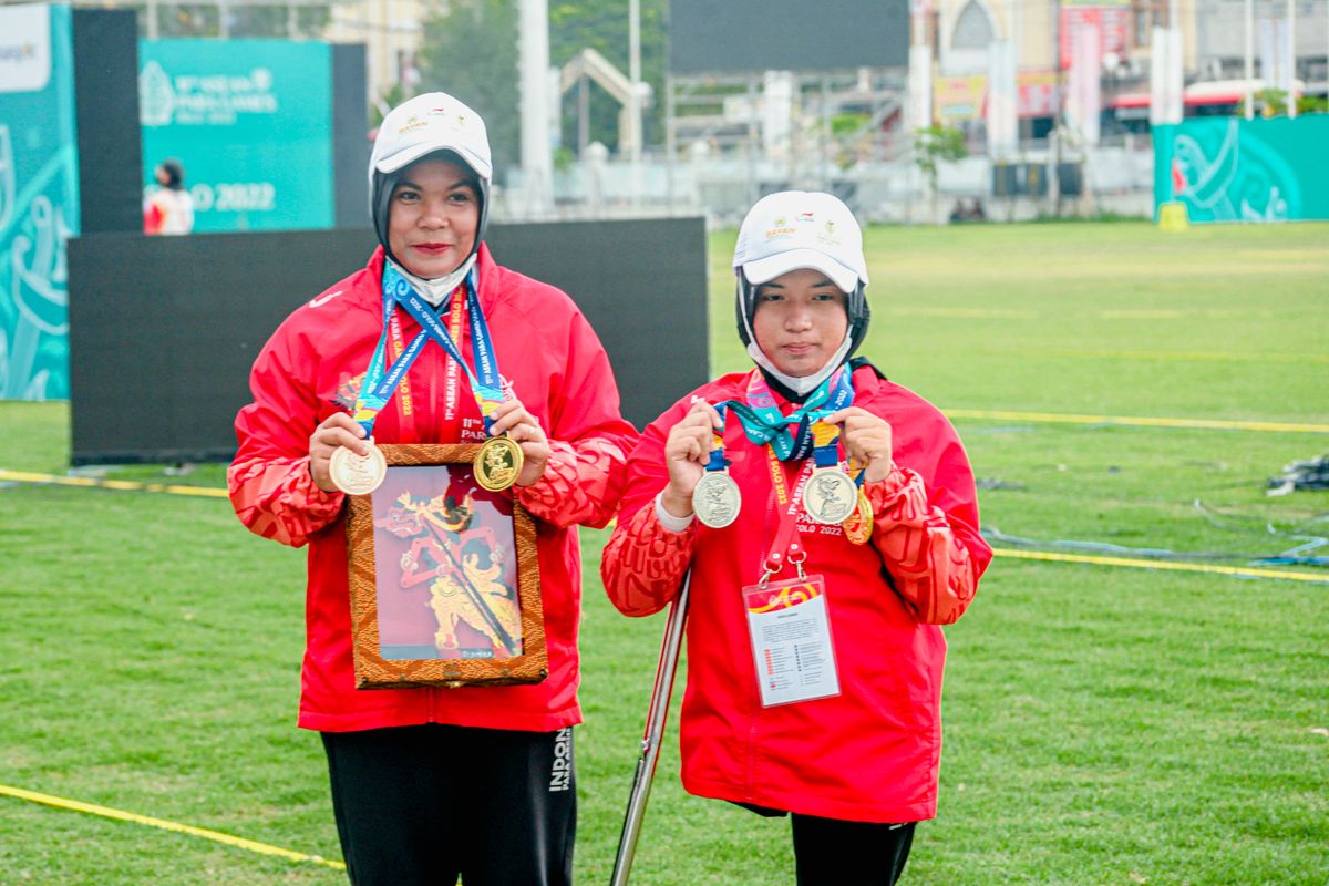 Indonesian archers Mahda Aulia (R) and Wahyu Retno Wulandari (L) posing with gold medals after competing in the final round of the recurve women?s open doubles of ASEAN Para Games at the Kota Barat Field in Solo, Central Java on Wednesday, Aug.3, 2022. 