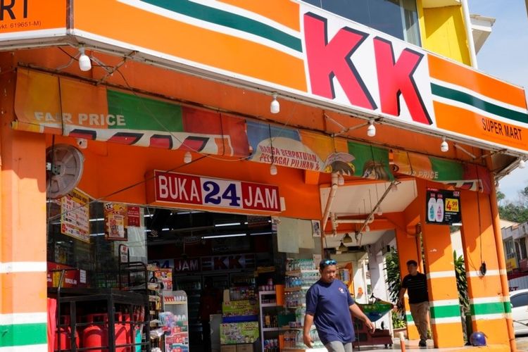 Seorang pelanggan keluar dari minimarket KK Mart di kawasan Puchong, pinggiran Kuala Lumpur, Malaysia, Selasa (26/3/2024).