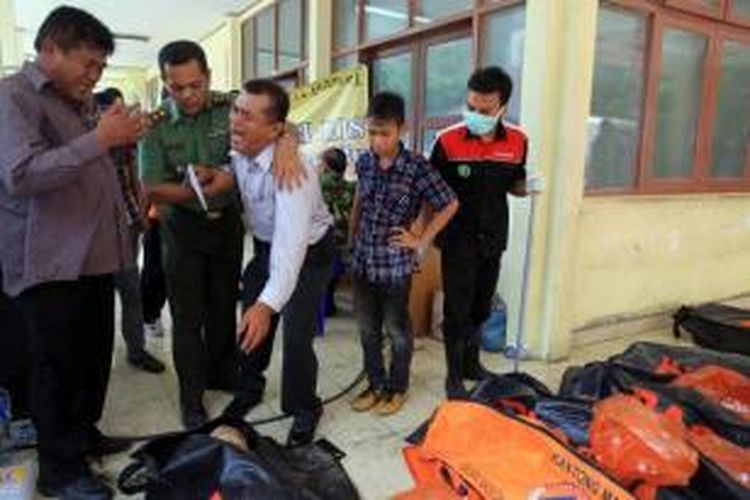 Keluarga korban penumpang jatuhnya pesawat Hercules C-130 milik TNI AU, menangis usai melihat jenazah keluarganya di Rumah Sakit Adam Malik, Medan, Rabu (1/7/2015). Pesawat jatuh dua menit setelah lepas landas dari Pangkalan Udara Soewondo pukul 12.08.