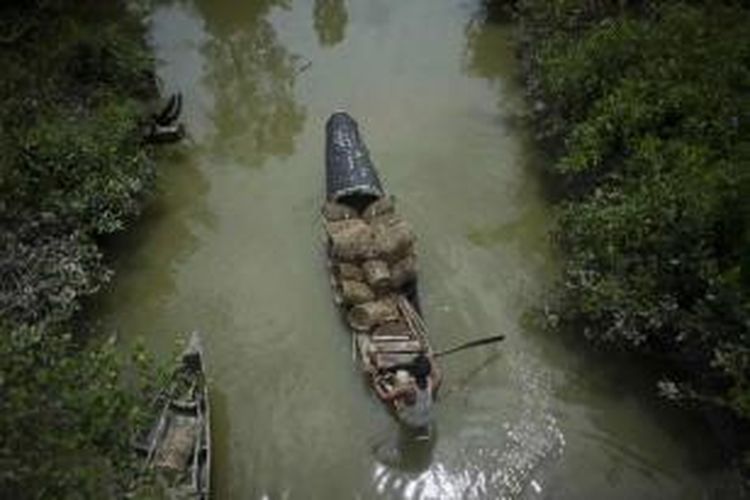 Nelayan mendayung perahunya ditengah rawa yang menjadi perbatasan Myanmar-Banglades, 5 Juni 2015. Lebih dari 700 migran yang ditemukan terkatung di atas kapal nelayan telah didaratkan di Rakhine, Myanmar dan dibawa ke kamp pengungsian sementara.