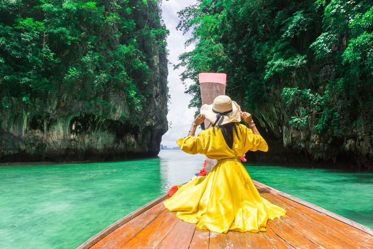 Seorang wisatawan menaiki long tail boat di Pulau Hong, Thailand. Thailand adalah salah satu negara yang bisa dikunjungi tanpa syarat tes PCR.