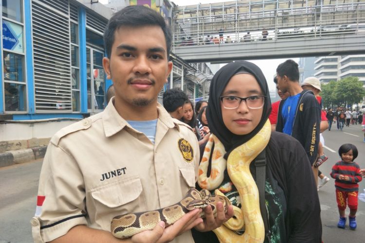 Ketua Room Pets Djakarta (RPD) Ilham (kiri) dan anggota RPD Sari (kananpl) memamerkan reptil peliharaannya di Jalan MH Thamrin, Jakarta Pusat, Minggu (9/12/2018).
