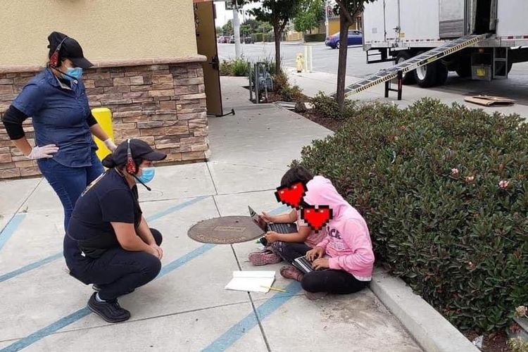 Foto dua siswi yang mencari Wi-Fi sambil lesehan di pinggir jalan California, Amerika Serikat, viral pada 28 Agustus 2020. Foto ini menunjukkan kesenjangan digital di Negeri Paman Sam.