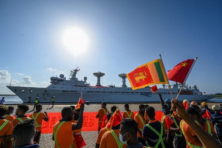 Para pekerja mengibarkan bendera nasional Tiongkok dan Sri Lanka setelah kedatangan kapal penelitian dan survei Tiongkok, Yuan Wang 5 di pelabuhan Hambantota pada 16 Agustus 2022.