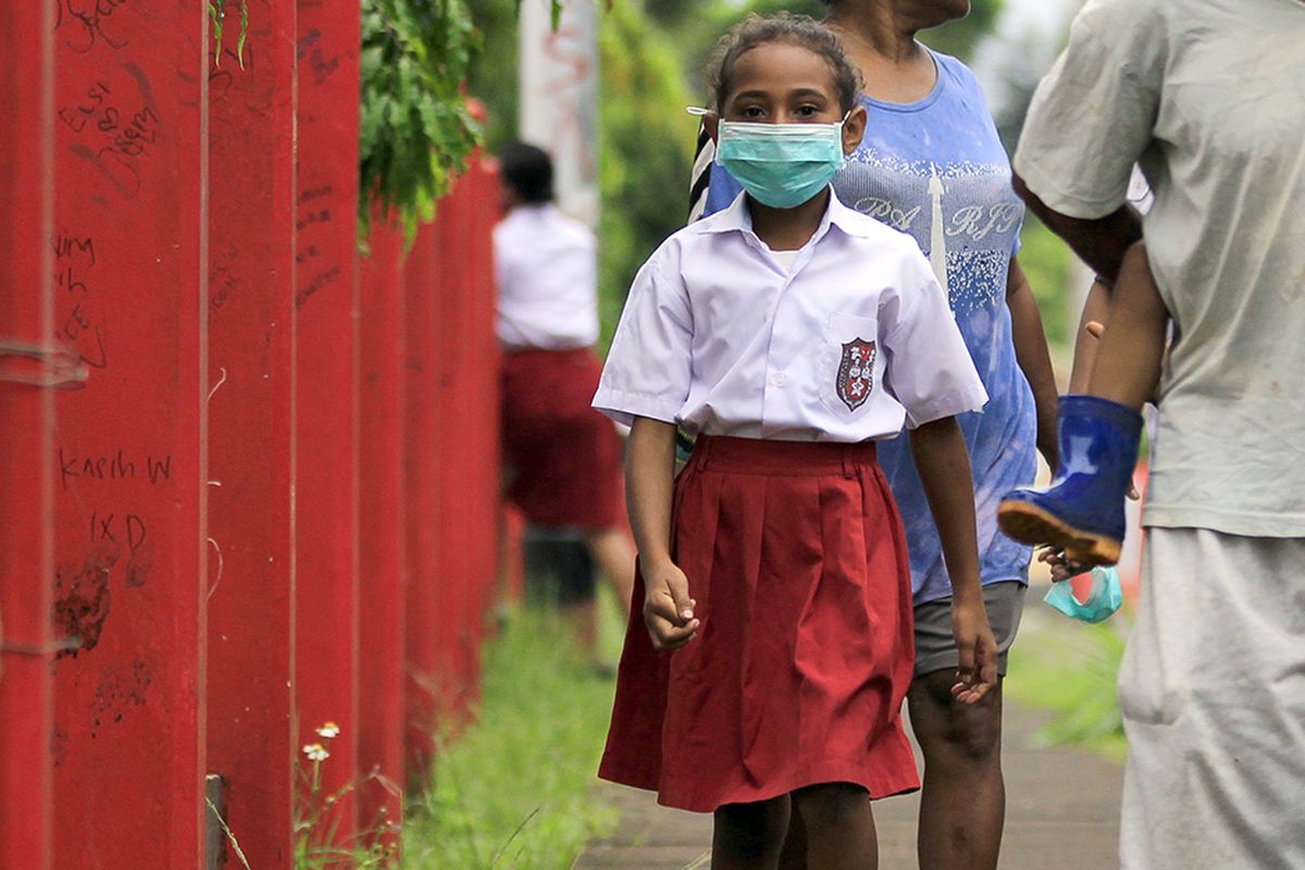 Seorang siswa SD dengan masker di wajahnya berjalan meninggalkan sekolah usai melakukan pendaftaran ulang pada hari pertama sekolah di Jayapura, Papua, Senin (13/7/2020). Siswa SD, SMP dan SMA mulai mengikuti kegiatan belajar-mengajar tahun ajaran baru 2020/2021 dengan sistem pembelajaran tatap muka langsung dan daring. ANTARA FOTO/Gusti Tanati/wsj.