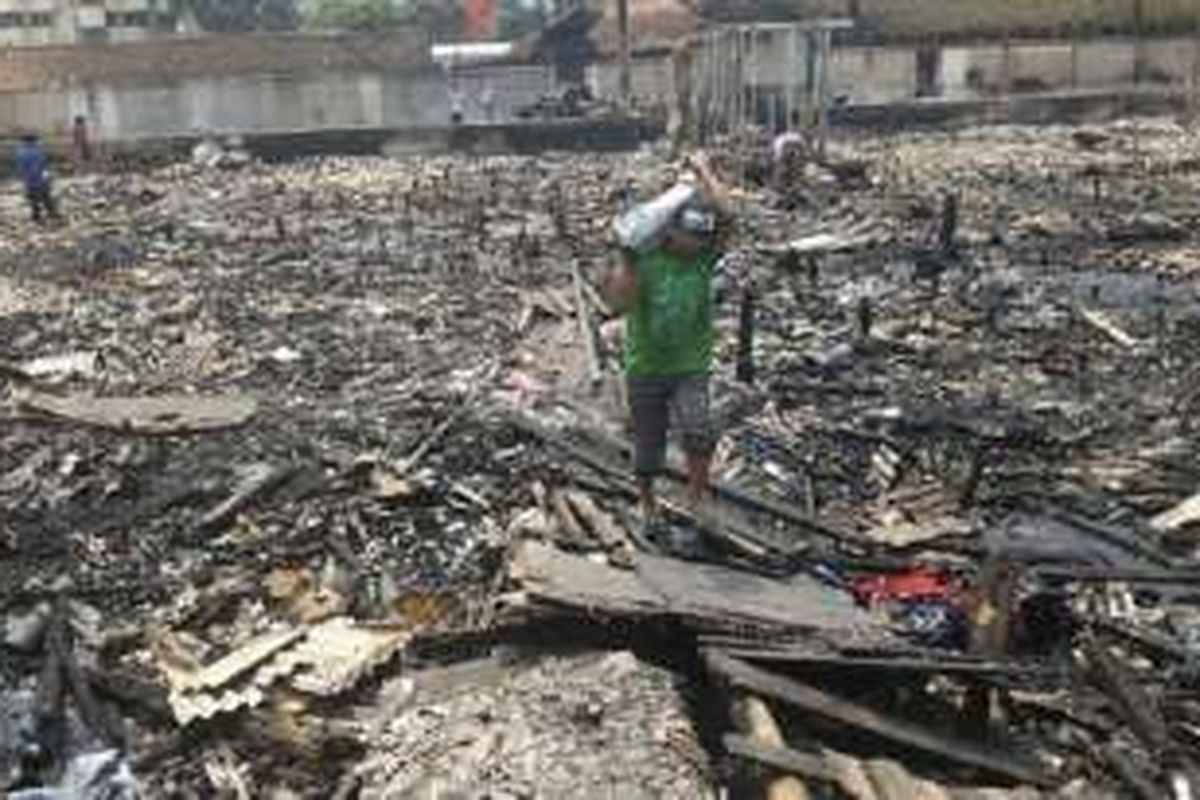 Warga dan pemulung mencari barang-barang yang masih dapat digunakan di reruntuhan rumah yang habis terbakar di Kampung Bandan, Ancol, Pademangan, Jakarta Utara, Rabu (27/1/2016). 