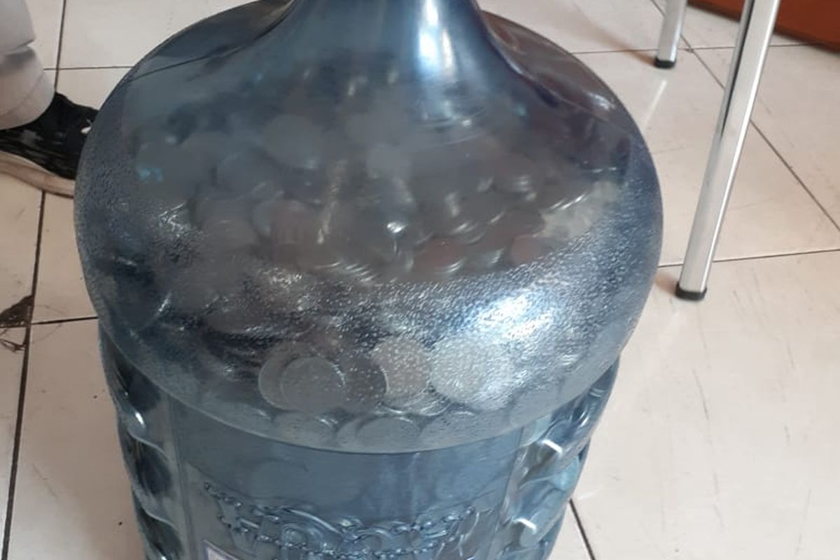 galon bekas air minum yang berisi penuh uang koin seribuan milik satria