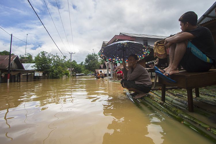 Warga menunggu evakuasi saat  banjir melanda Desa Sungai Raya, Kabupaten Banjar, Kalimantan Selatan. Hujan tiada henti pada Selasa (12/1/2021) berujung petaka dengan meluapnya sungai hampir di seluruh wilayah Kalimantan Selatan, sedikitnya 11 kabupaten/kota porak poranda diterjang banjir termasuk Kota Banjarmasin.